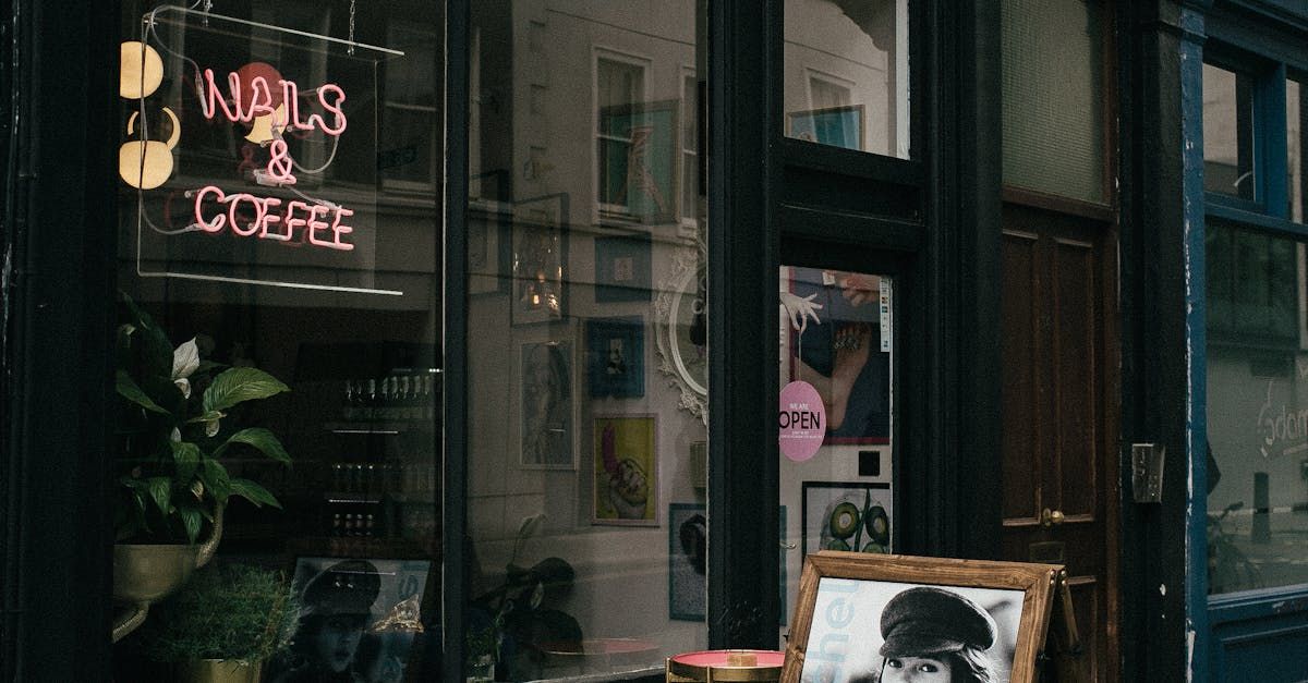 London shop owner applying vinyl signage at sunrise