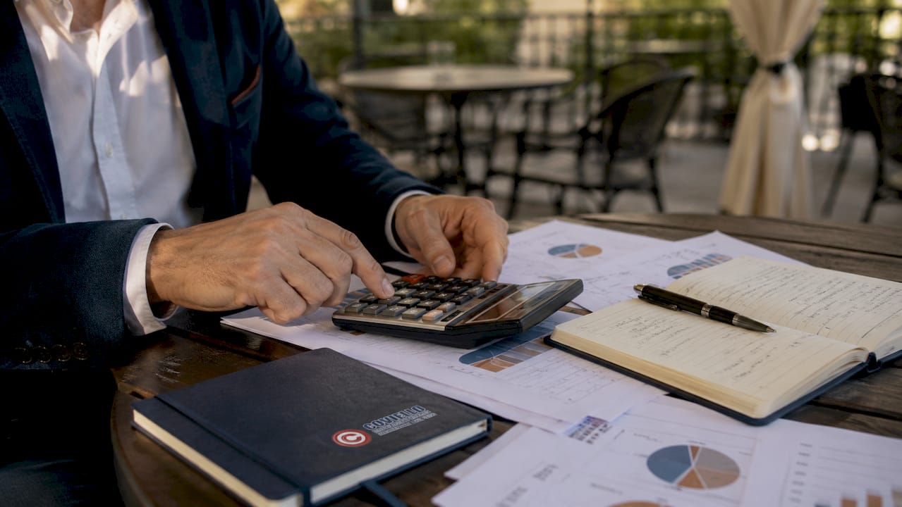 Una persona sta facendo i conti con la calcolatrice per valutare l’aspetto economico.