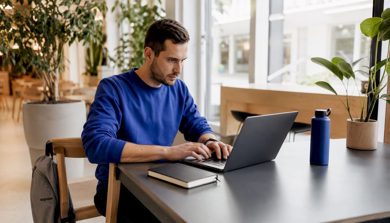 IT strokovnjak v sodobnem coworking prostoru hitro in zbrano tipka po tipkovnici.