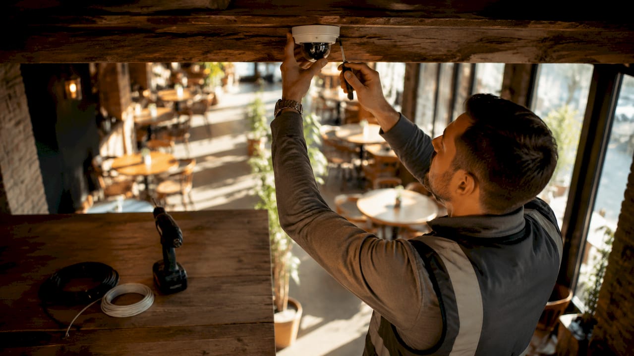 Technician installing CCTV camera outdoors