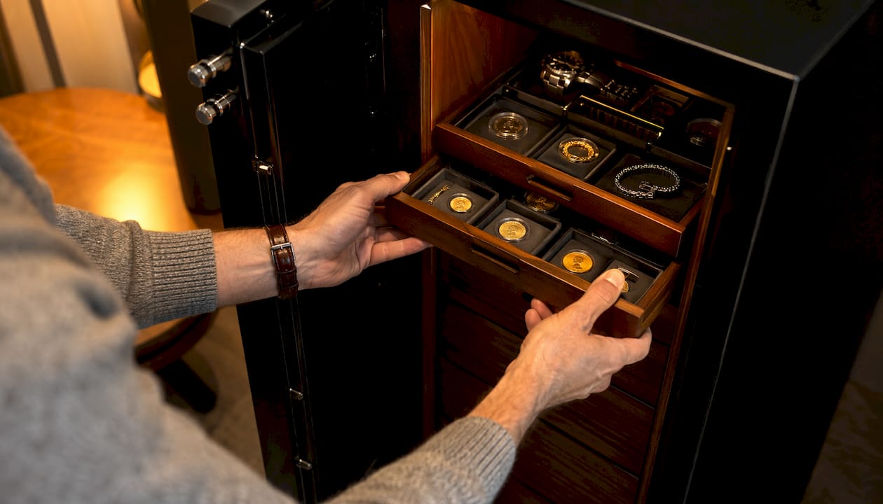 Hands inserting shallow drawers into safe