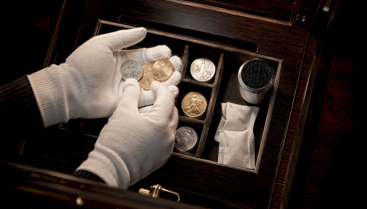 Gloved hands arranging coins with desiccant