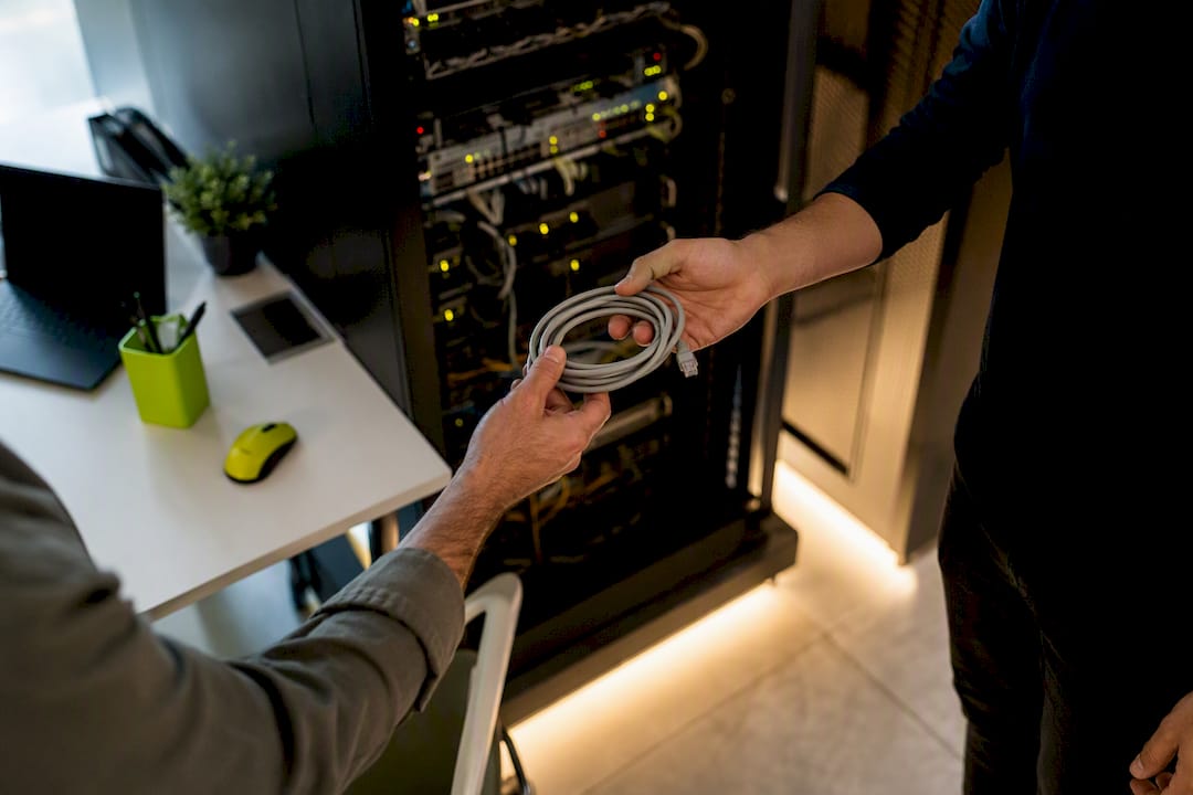 Hands connecting cables in server room