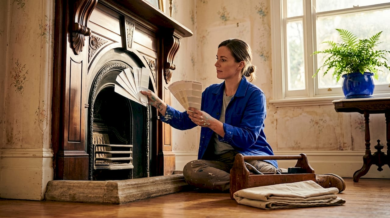 Specialist tests paint strips near heritage fireplace