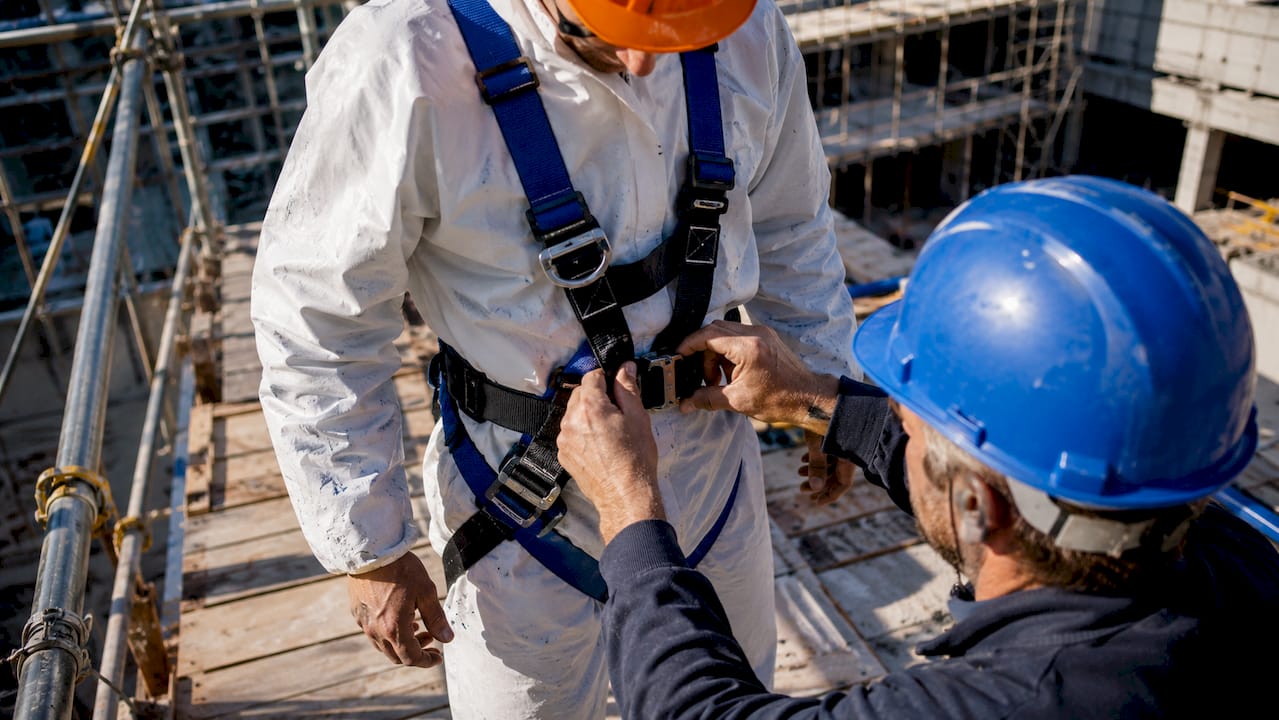 Close-up of safety harness buckle being fastened