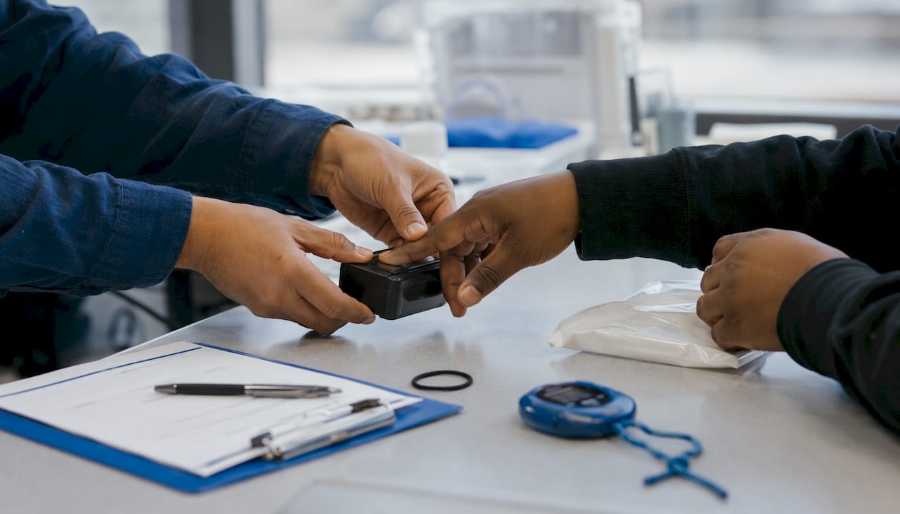 Hands operating fingerprint scanner during testing workflow
