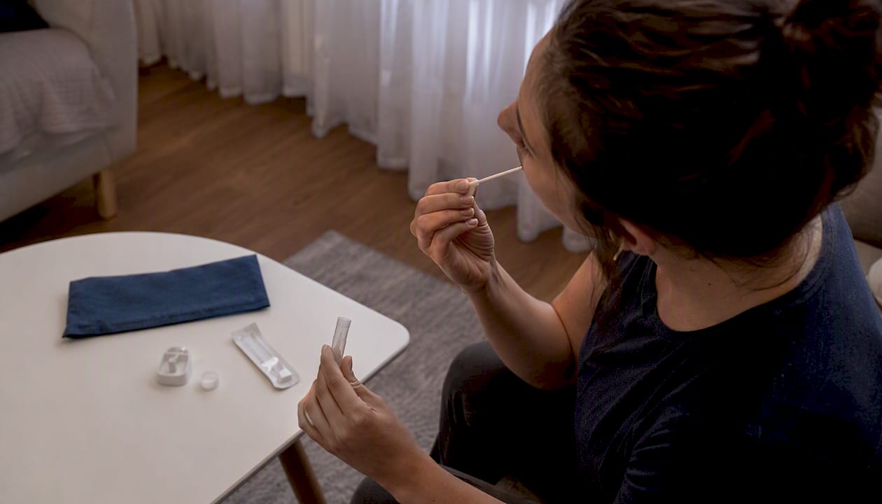 Hands collecting oral fluid sample for HIV home test