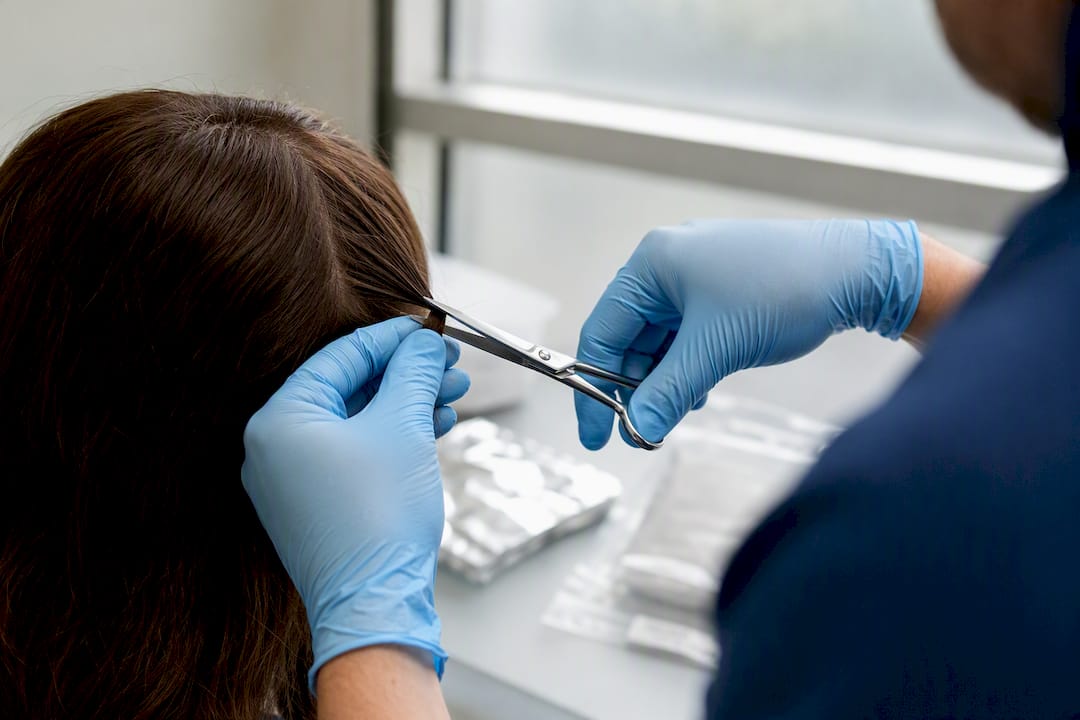Hands cutting hair sample for drug test