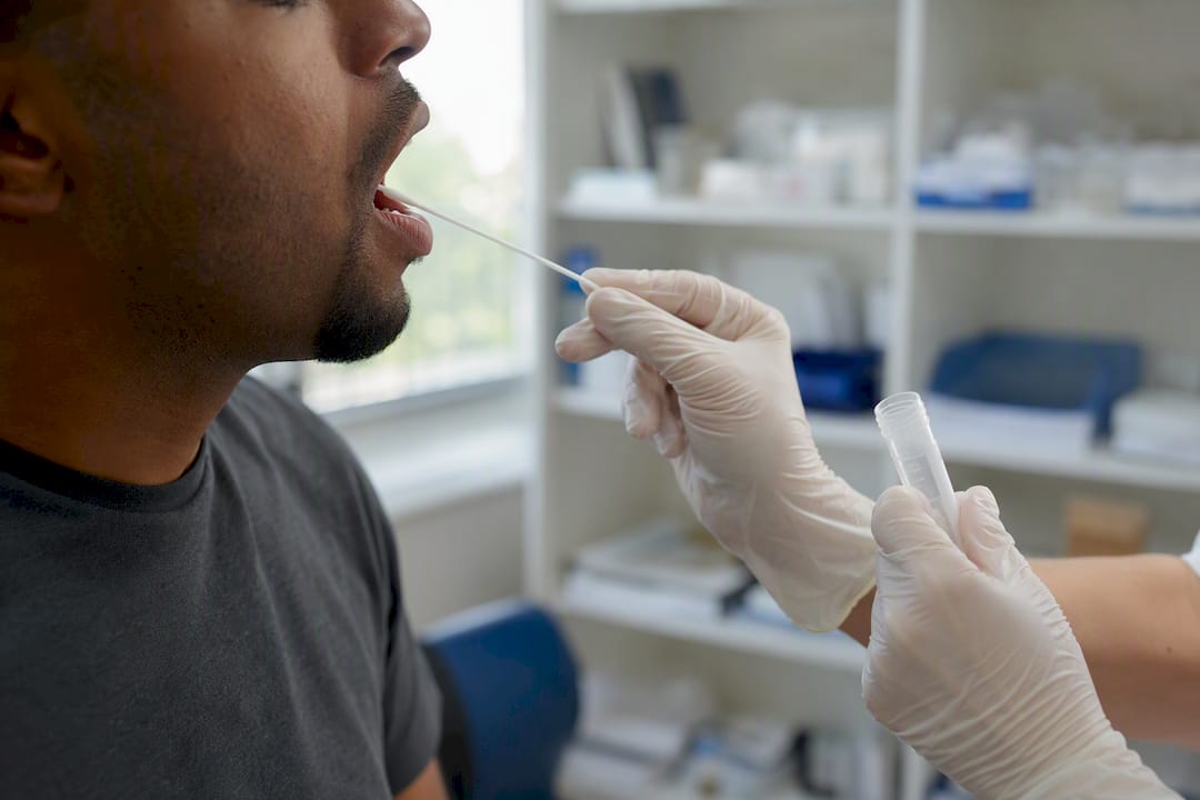 Hands swabbing saliva for oral fluid drug test