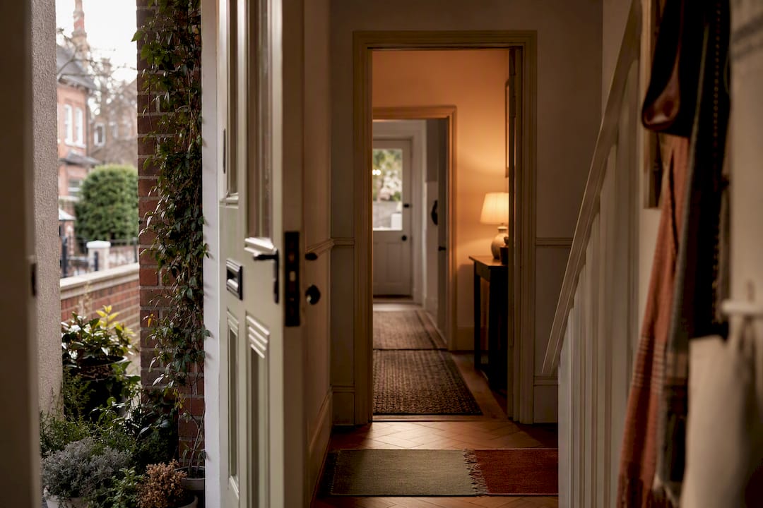 Open front door leading into coordinated hallway