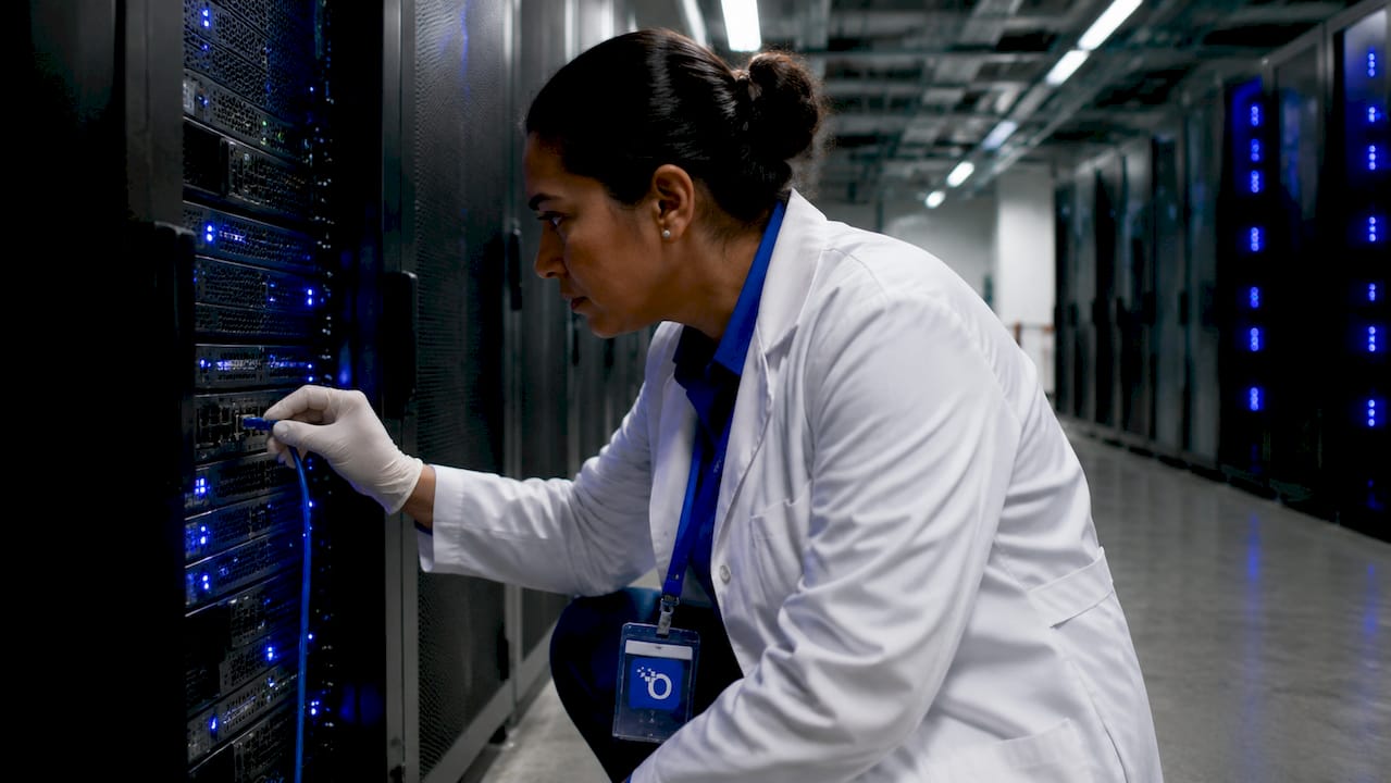 Technician connecting cable in secure data center