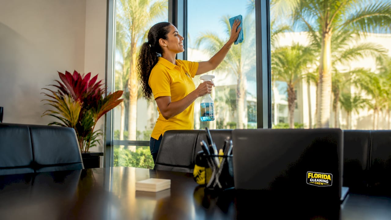 Office manager inspecting clean window in bright office