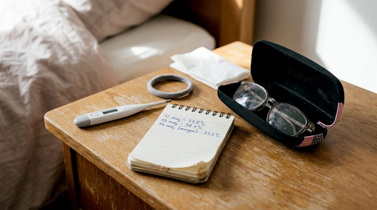 Fertilitetsrelaterade hjälpmedel ligger på det lilla nattduksbordet i trä.