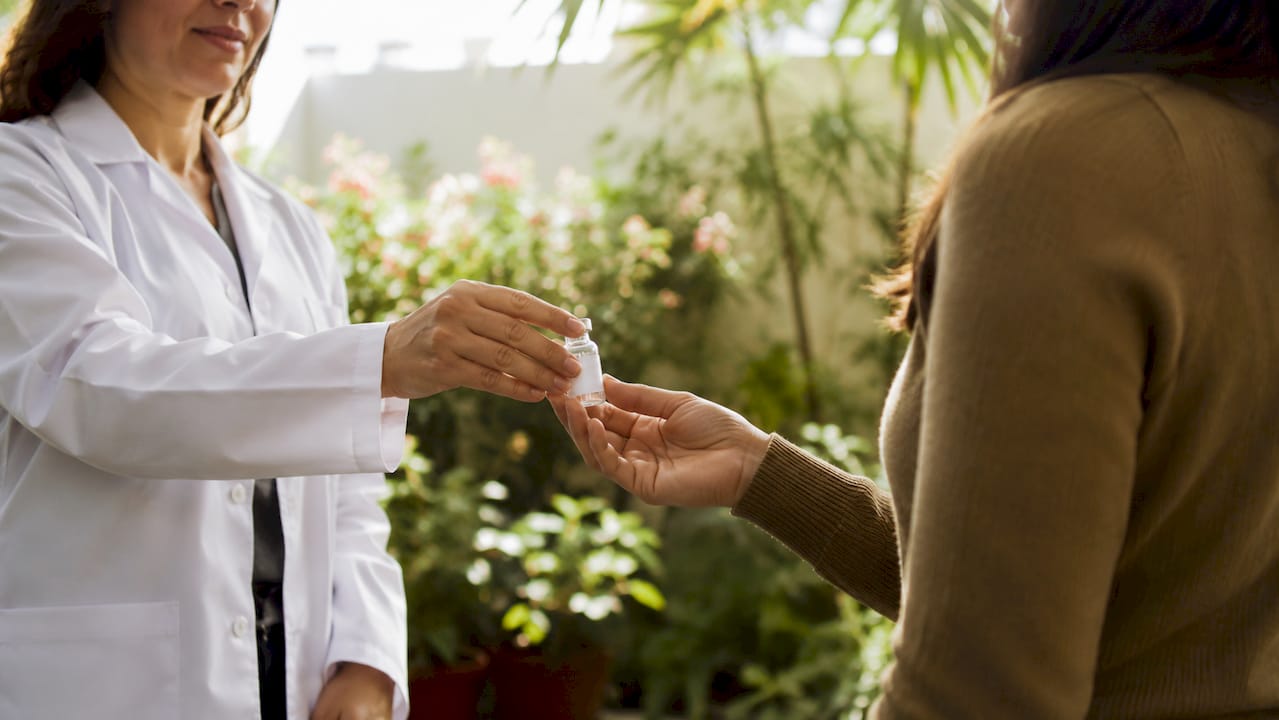 Hands exchanging sterile medication at pharmacy counter