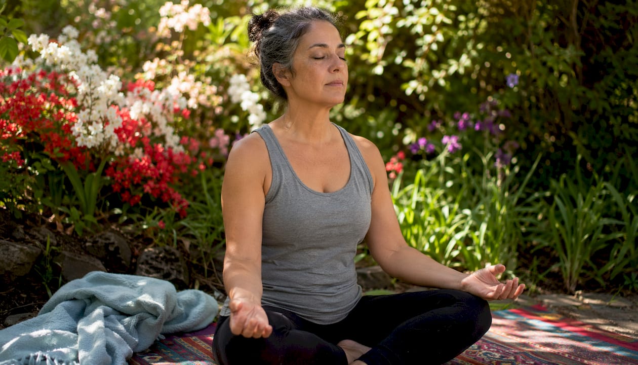Woman practicing somatic body awareness exercise on mat