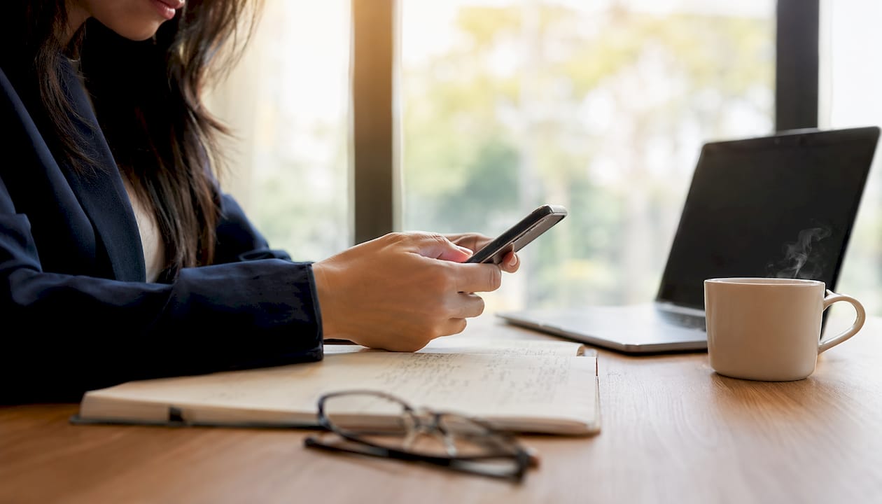 Vrouw geeft via haar smartphone door aan de verzekeraar dat haar woning tijdelijk leeg staat.