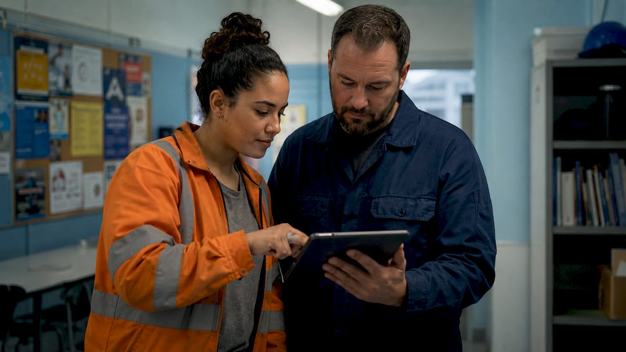 Factory operators entering downtime data on tablet