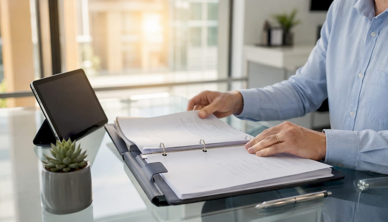 Hands typing near OM manual documents