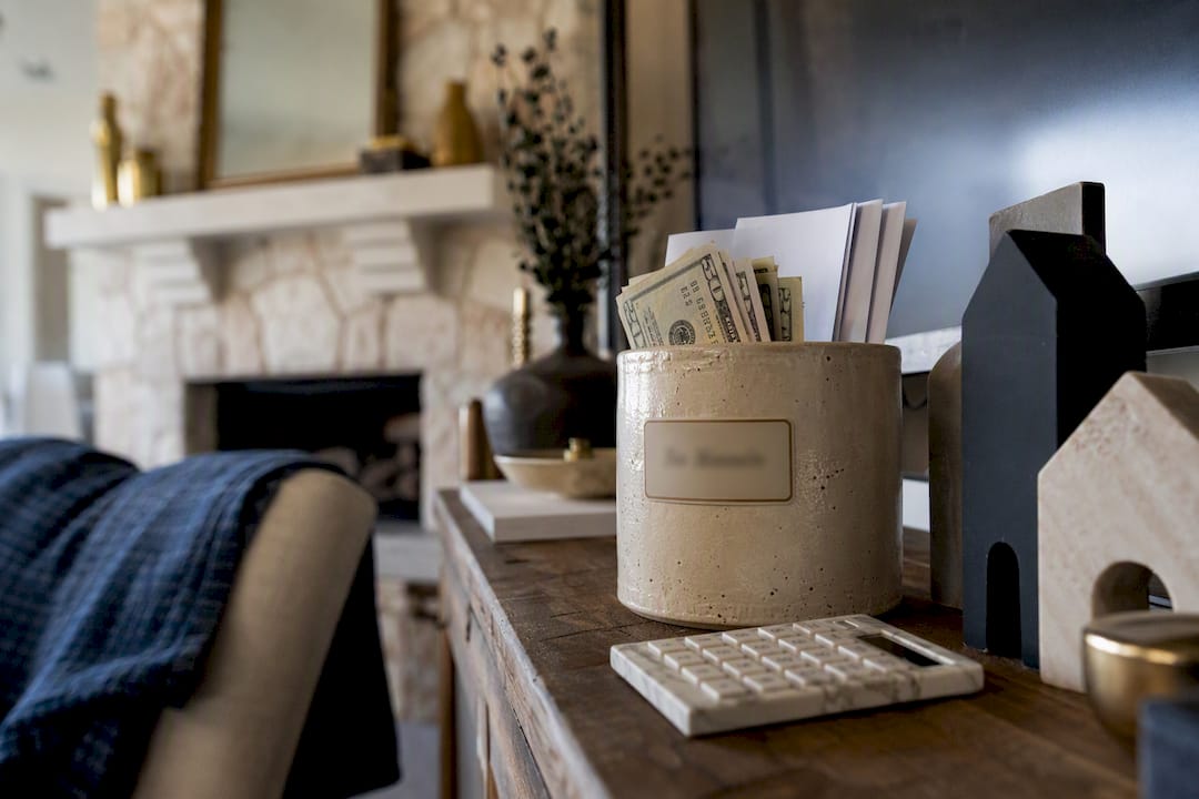 Jar with cash labeled property tax escrow near calculator