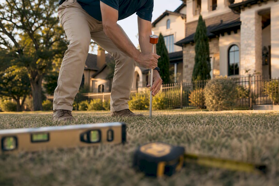 Surveyor setting boundary marker stake outdoors