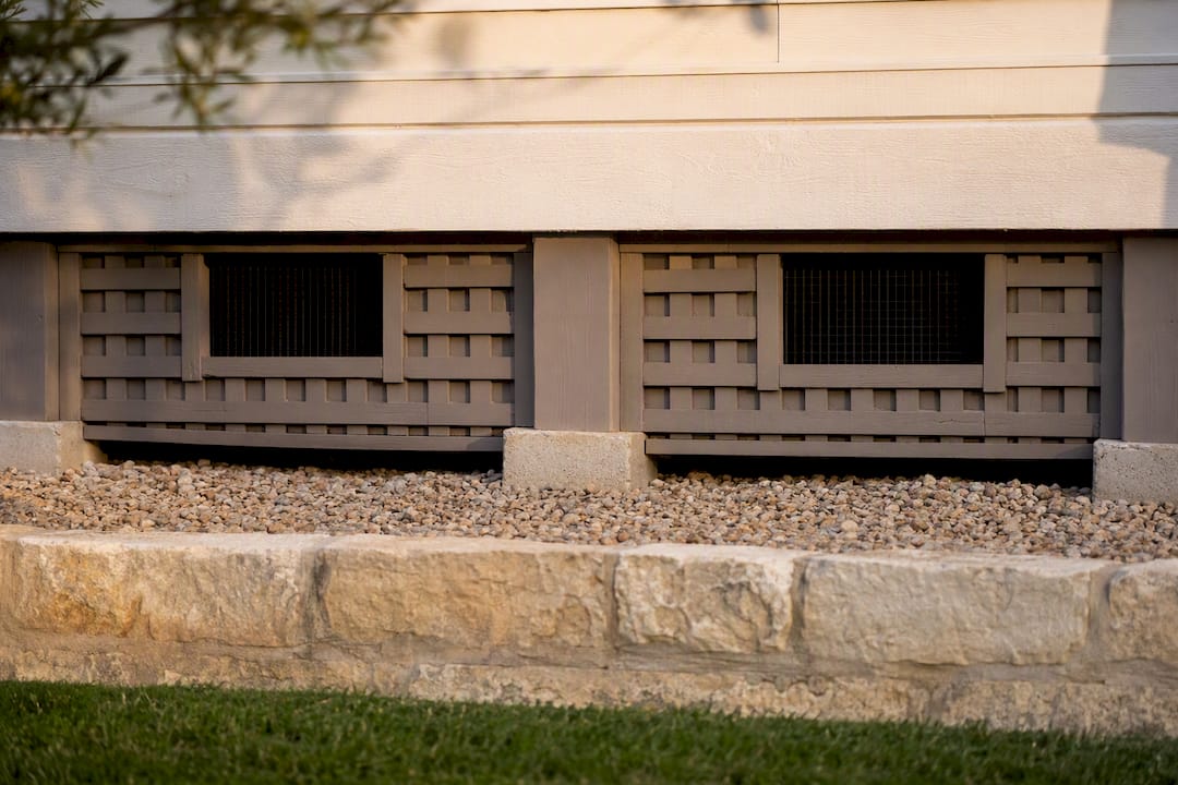 Crawlspace vents beneath a raised Austin home