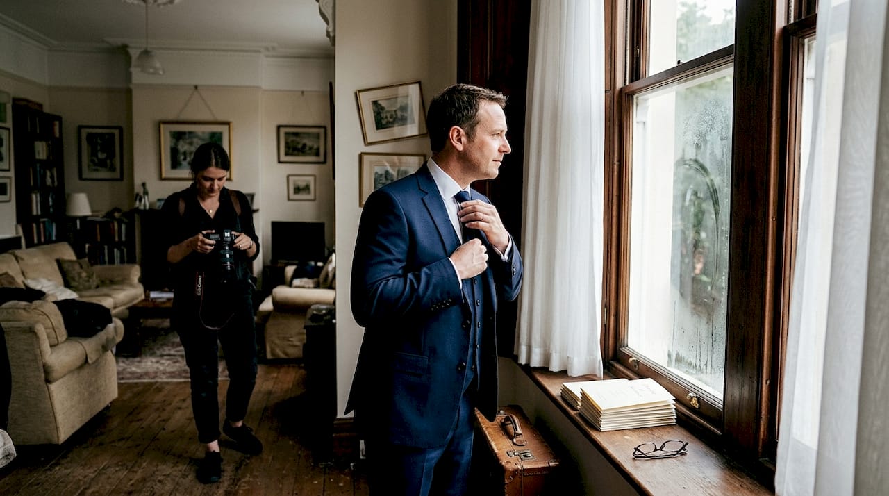 Groom prepares in townhouse for editorial wedding