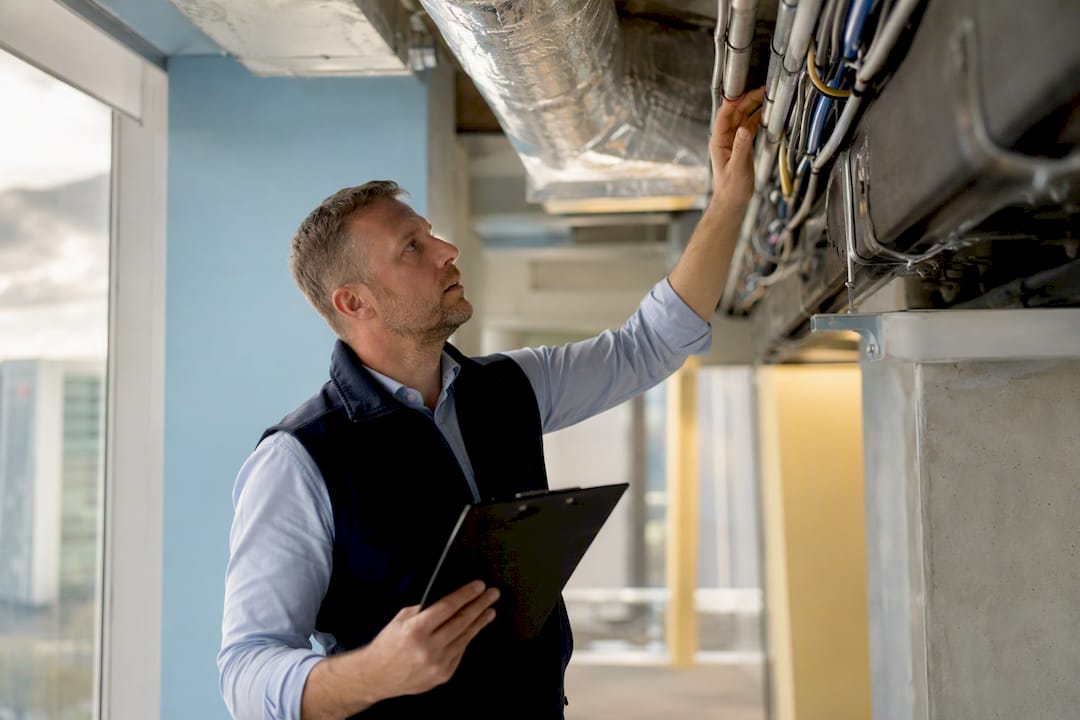 Un expert vérifie l’état et le bon fonctionnement des installations techniques d’un bâtiment.