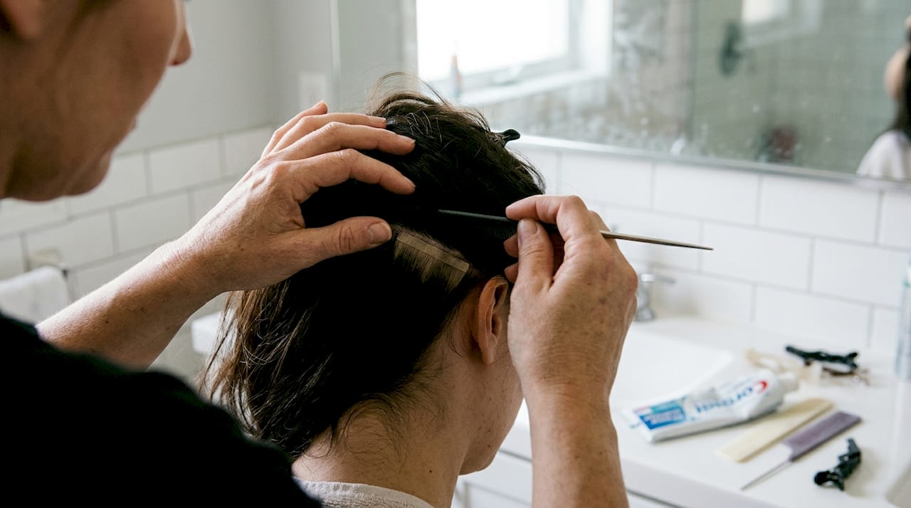 Closeup showing tape-in hair extension attachment