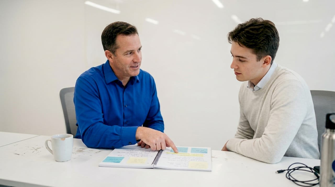 Sales leader coaching rep with notes between them