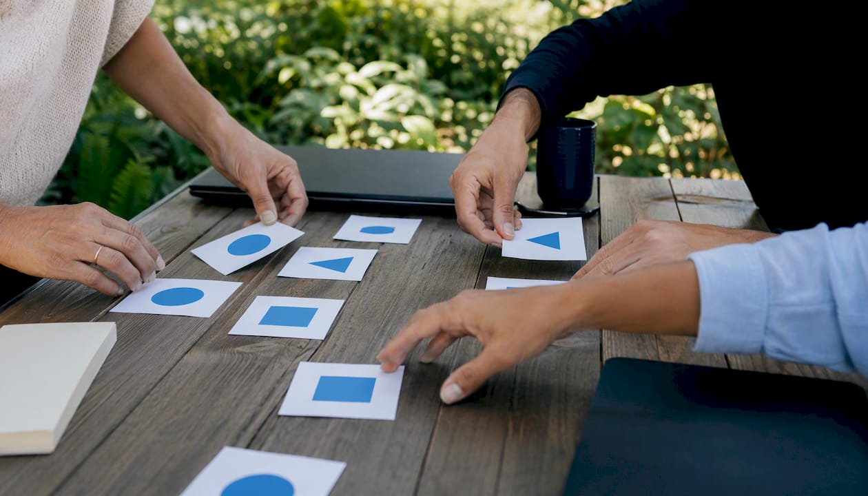 Hands distributing role cards on table
