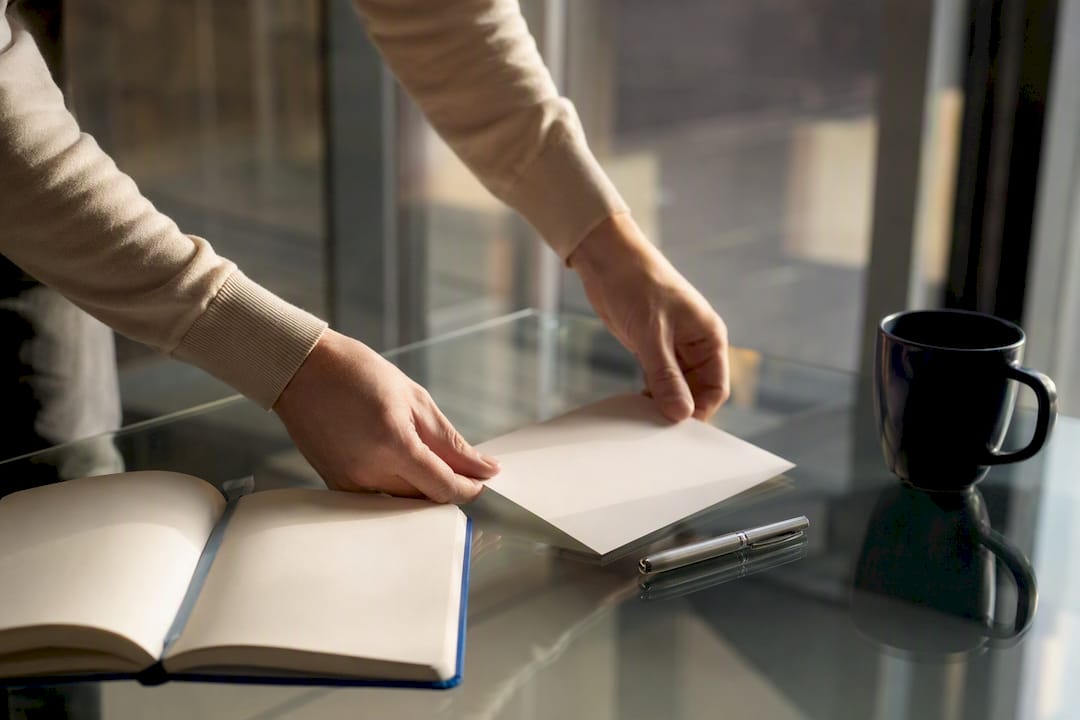 Hands engaging with onboarding checklist and coffee cup