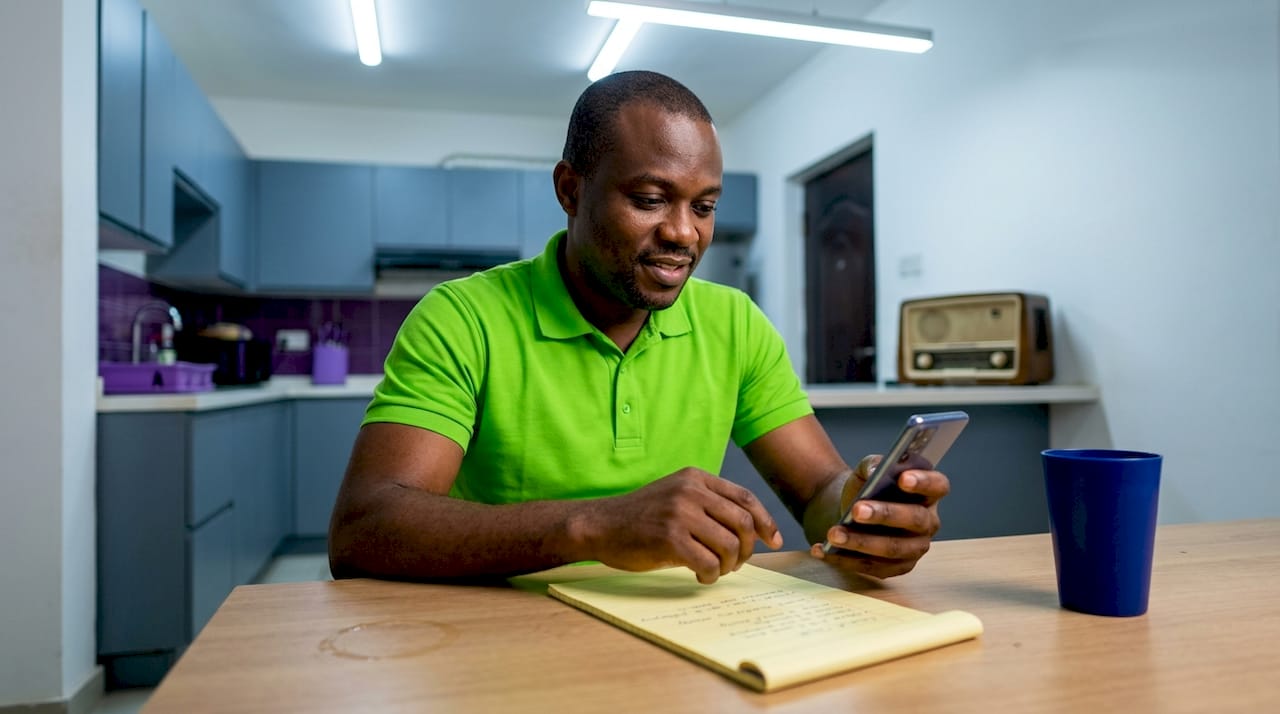 Man emailing news tip from home table
