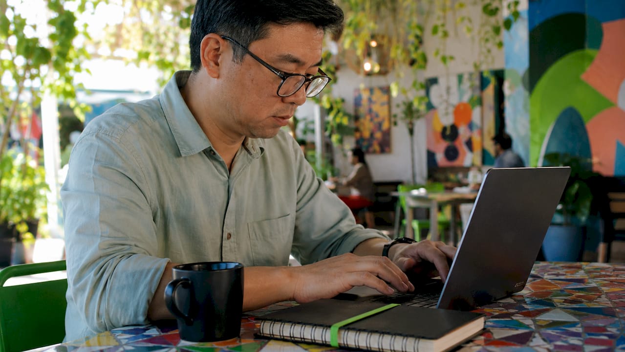 Advantages of E-Learning: Key Benefits Explained 2 Man scheduling self-paced e-learning sessions in café