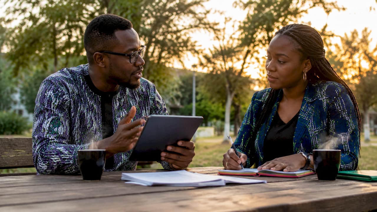 Why Regulate Digital Platforms: A Guide for Nigerians 2 Two people discussing digital platform regulation outdoors