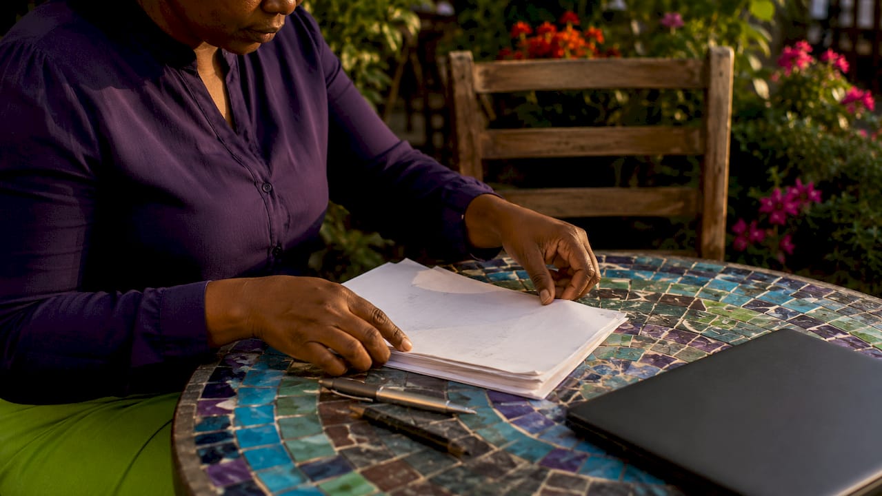 Hands organizing writing tools on desk