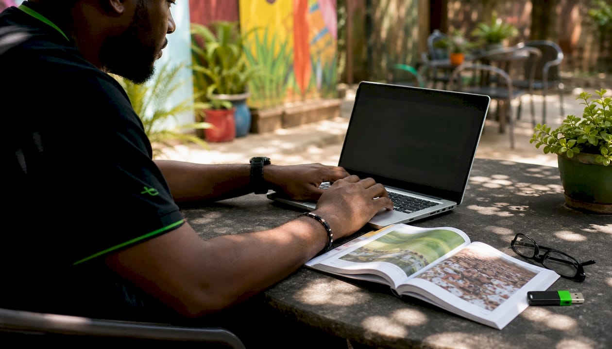 Hands configuring tablet with travel tools on desk