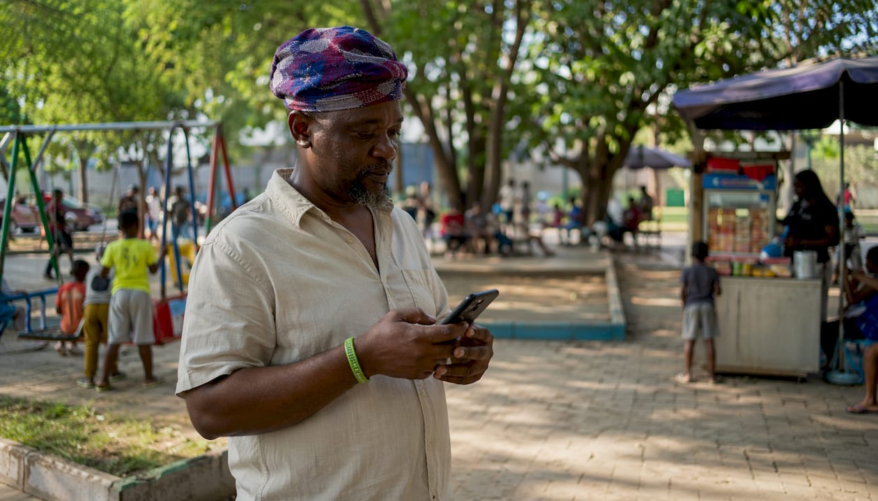 Nigerian man using phone app to report issues outdoors