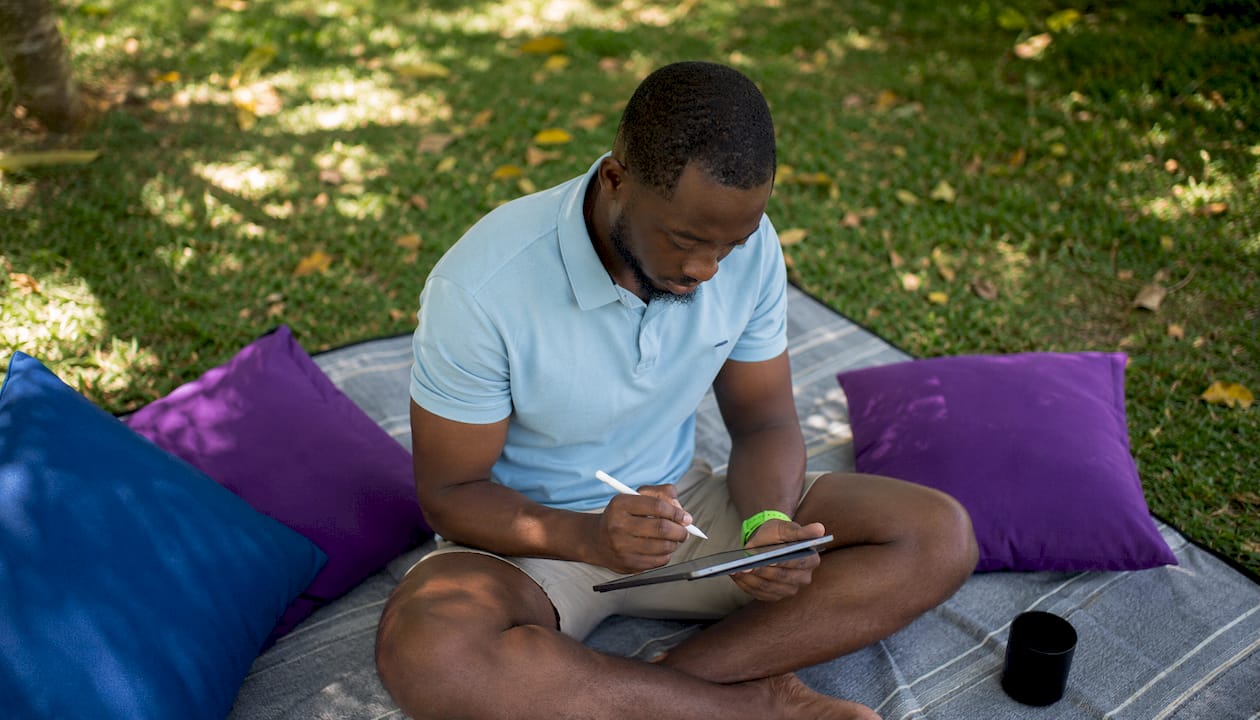 African man crafting CTA on tablet in outdoor café