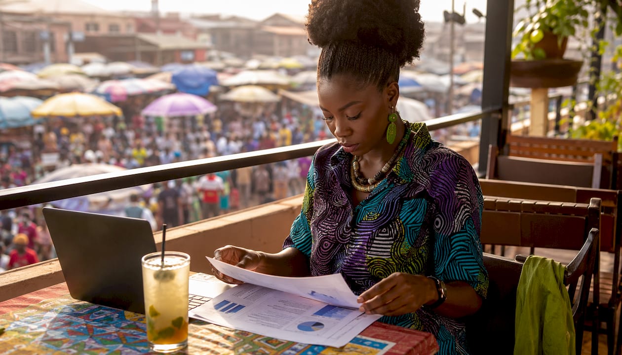 African female analyst reviewing market data papers
