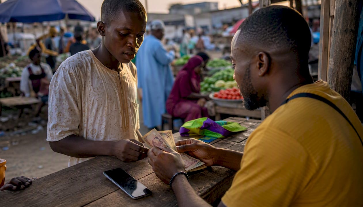Nigeria's Cashless Policy: What You Need to Know 2 Mobile money agent handling cash and smartphone