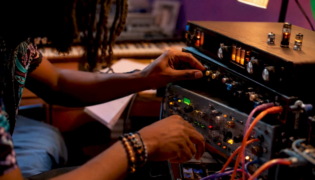Hands adjusting analog audio studio gear