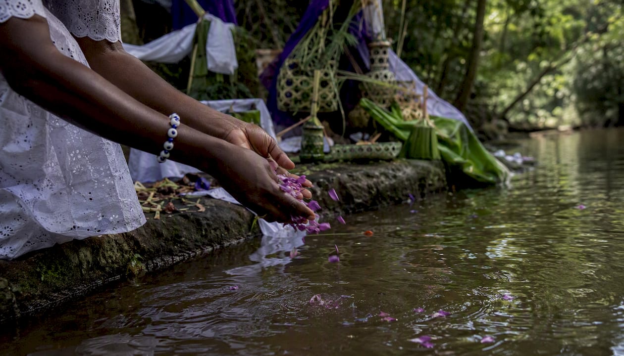 Hands performing water offering ritual at Osun-Osogbo