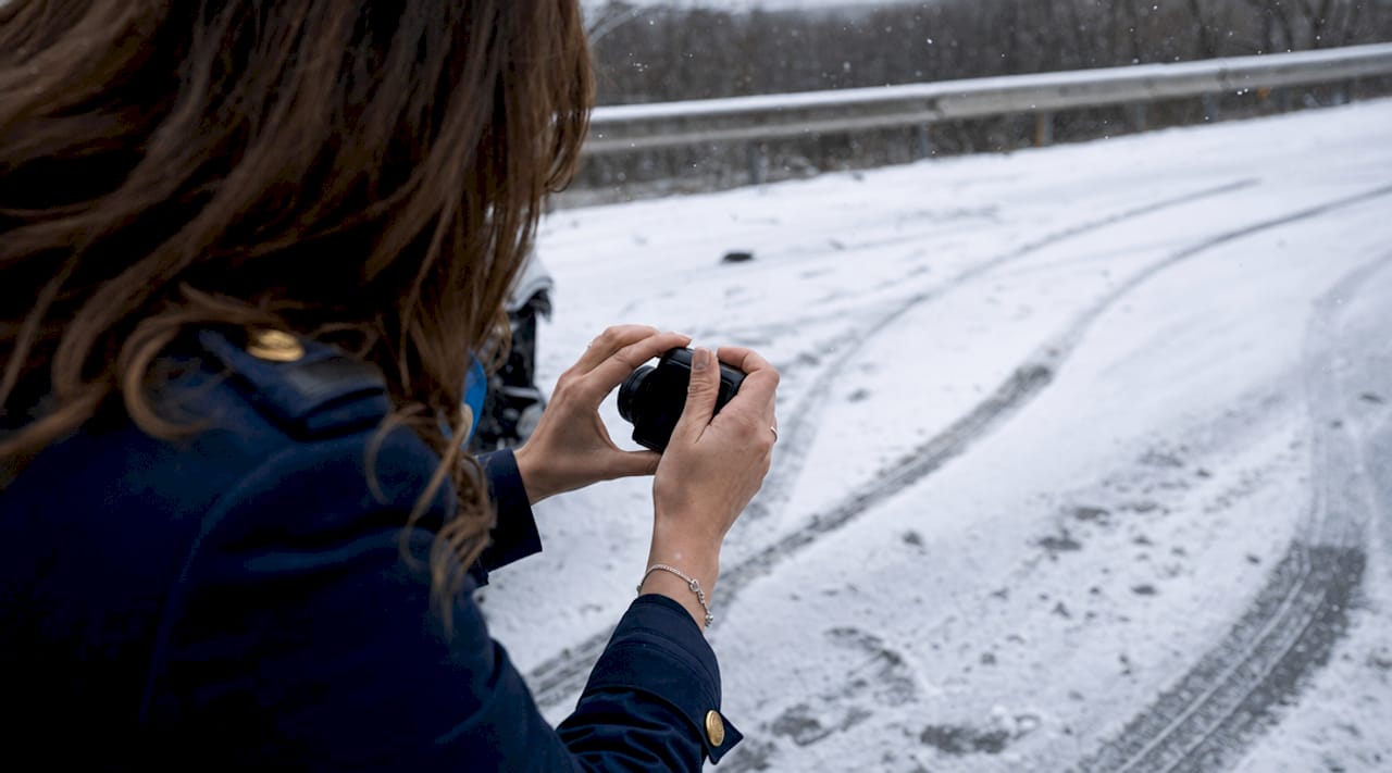 Hands photographing accident scene evidence