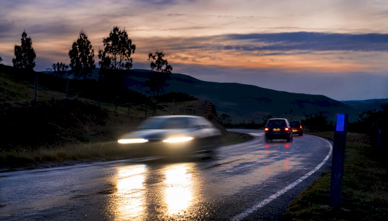 Blurred speeding car on rural highway at dusk