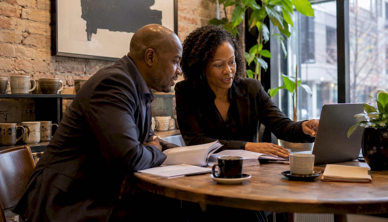 Two professionals discussing project governance and vendor contracts