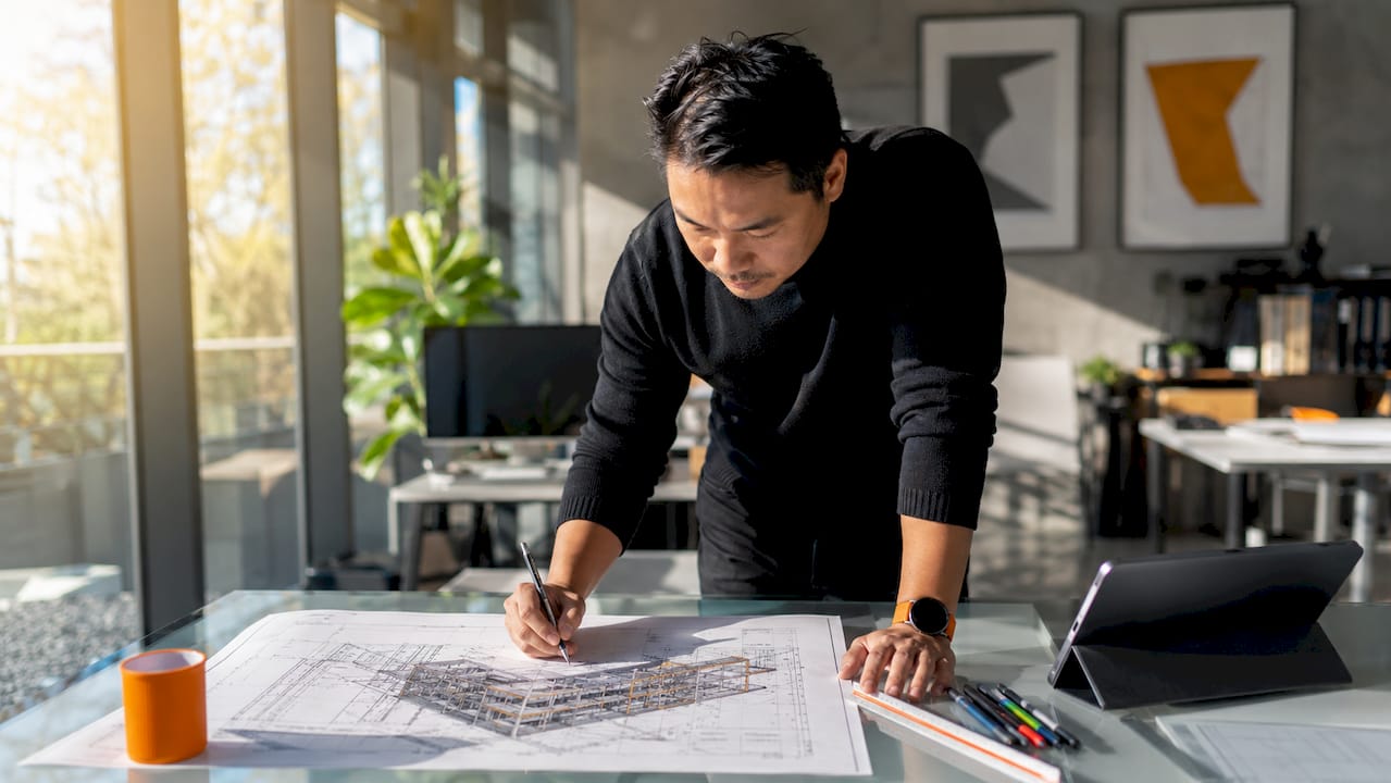 Architect reviewing BIM model blueprint at desk