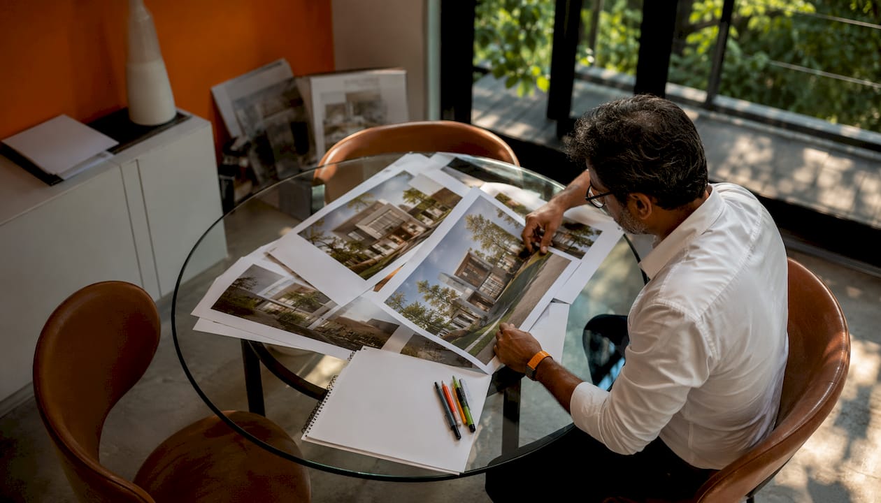 Architect reviewing 3D renderings at desk