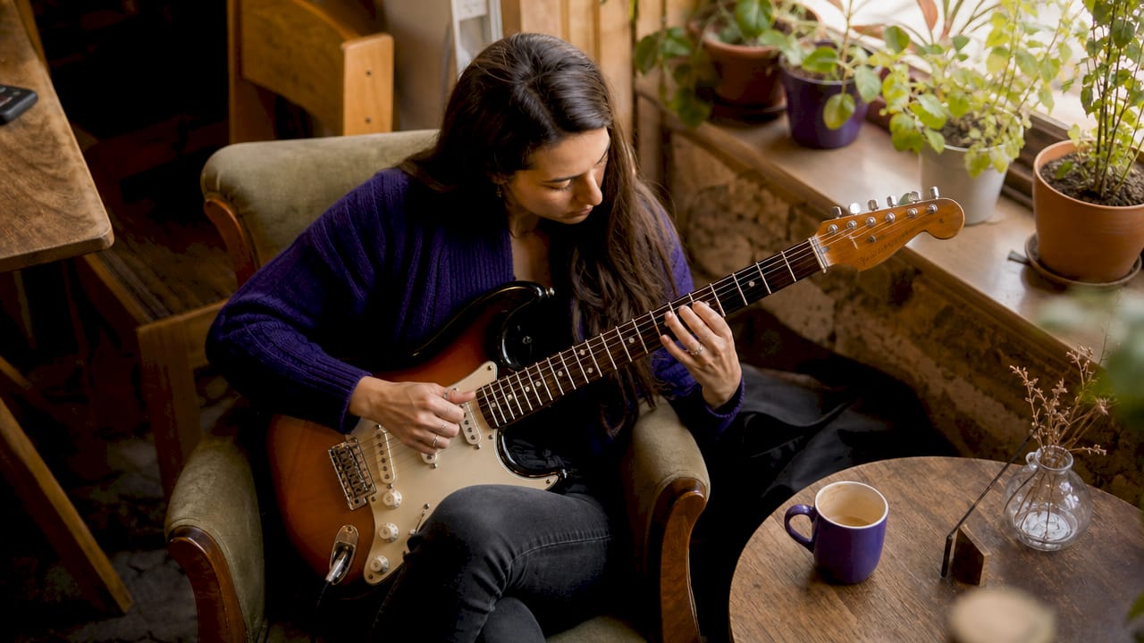 Close-up side view of guitarist practicing chords