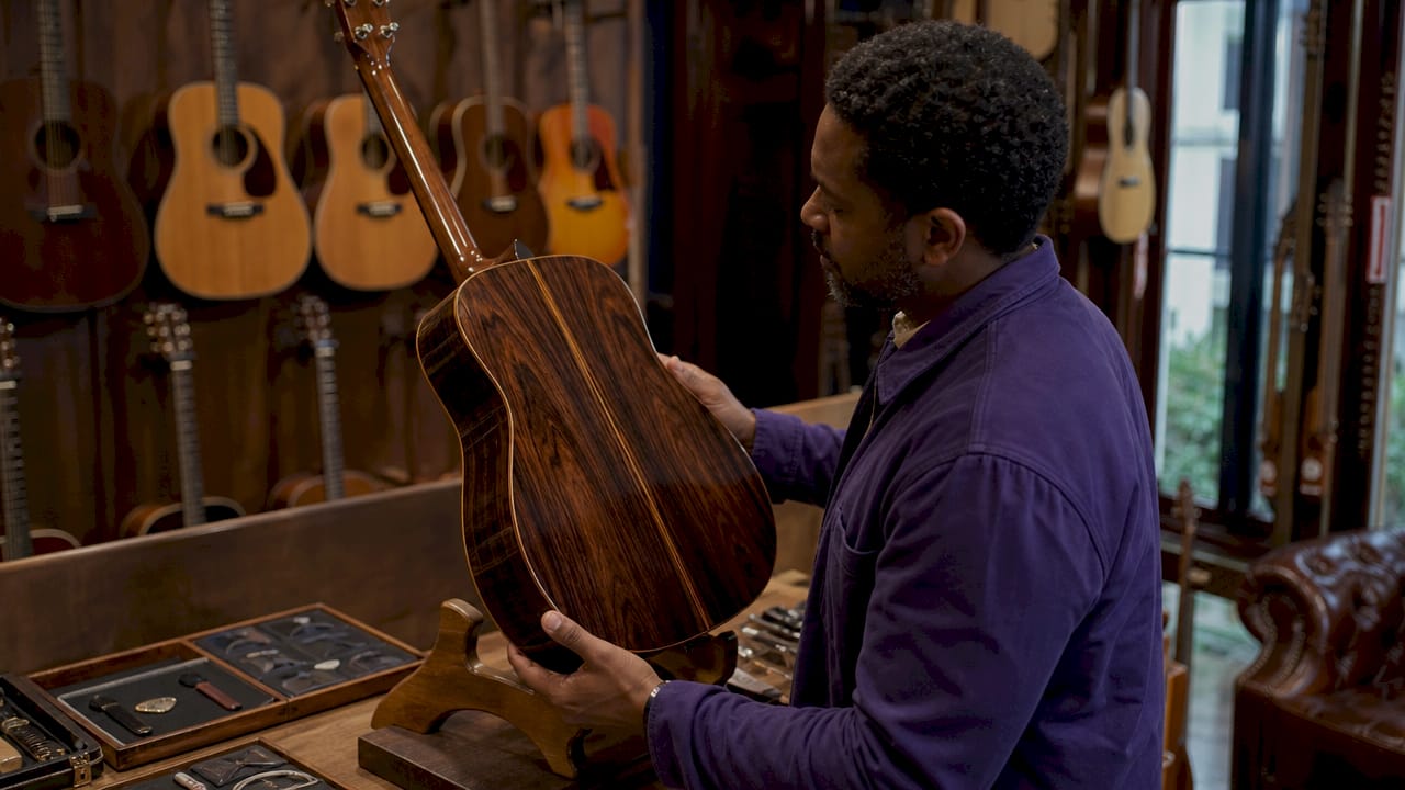 Collector inspecting Brazilian rosewood acoustic guitar