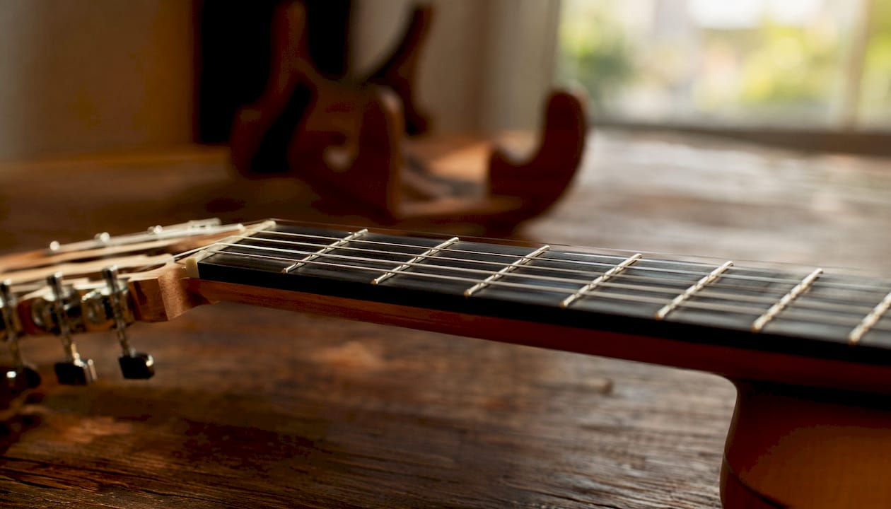 Detailaufnahme vom Gitarrenhals mit Fokus auf die Saitenlage und das Stimmgerät